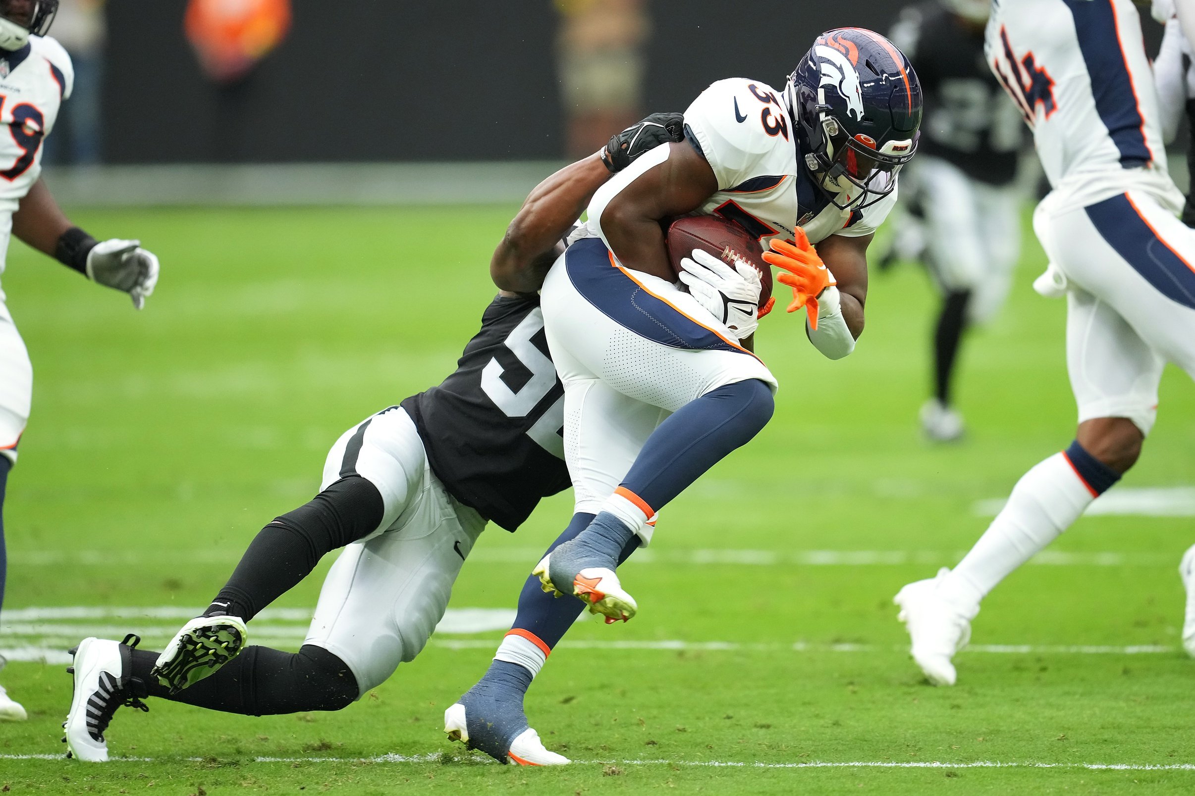 Javonte Williams of the Denver Broncos is upended by Jonathan