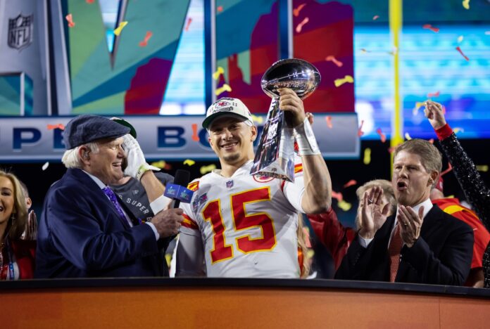 Patrick Mahomes (15) celebrates with the Vince Lombardi Trophy alongside Fox host Terry Bradshaw after defeating the Philadelphia Eagles during Super Bowl LVII at State Farm Stadium.
