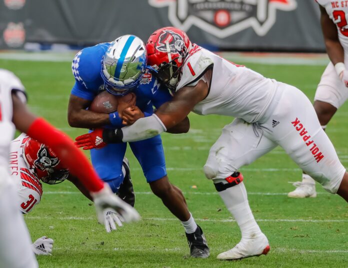 Kentucky Wildcats quarterback Terry Wilson (3) is tackled by North Carolina State Wolfpack linebacker Isaiah Moore