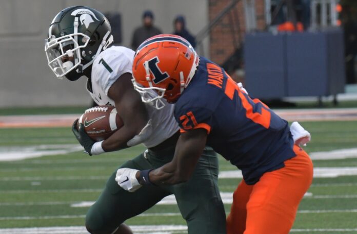 Michigan State Spartans wide receiver Jayden Reed is tackled by Illinois Fighting Illini defensive back Jartavius Martin.