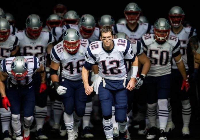 Quarterback Tom Brady (12) leads the New England Patriots out onto the field.