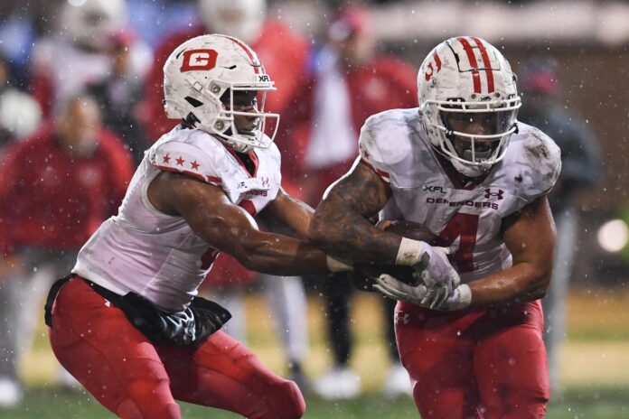 DC Defenders quarterback D'Eriq King (3) hands the ball off to running back Abram Smith (4).