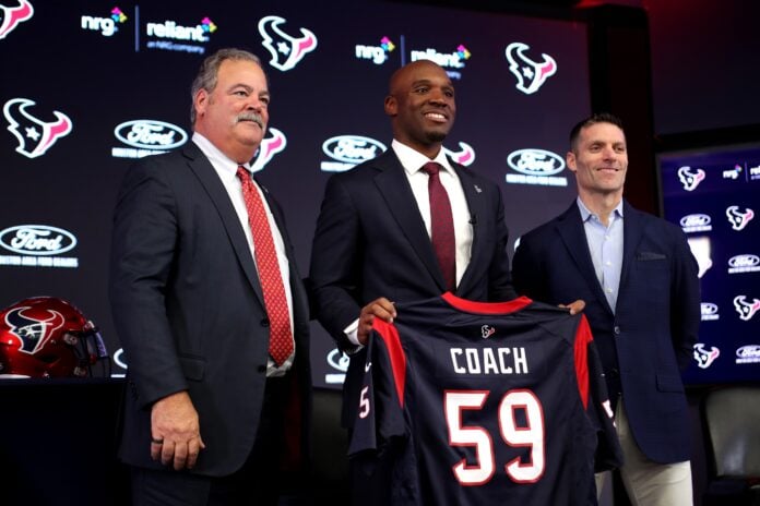 Houston Texans head coach DeMeco Ryans holds a jersey while posing for a photo.