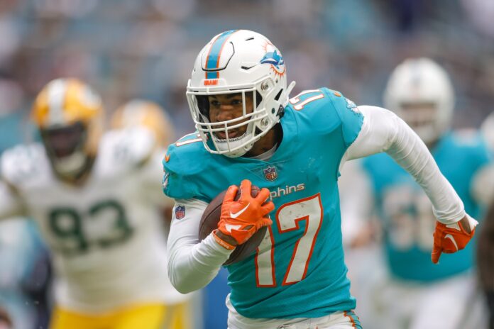 Miami Dolphins WR Jaylen Waddle (17) runs away from Green Bay defenders.