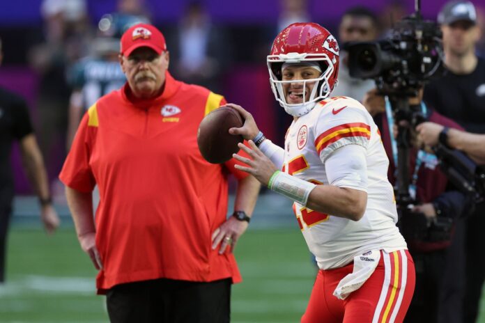 Kansas City Chiefs quarterback Patrick Mahomes (15) warms up before a game while head coach Andy Reid watches on.