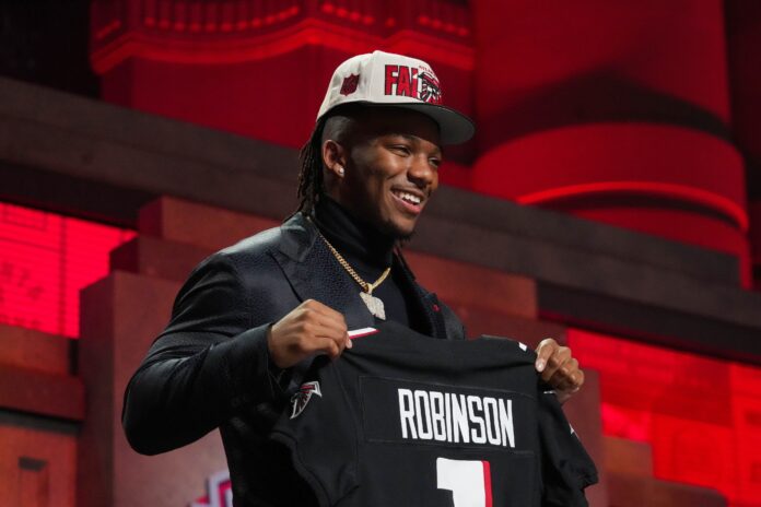 RB Bijan Robinson poses for pictures after being selected by the Atlanta Falcons in the 2023 NFL Draft.