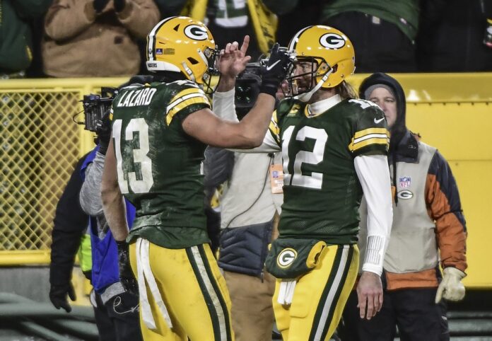 Quarterback Aaron Rodgers (12) and wide receiver Allen Lazard (13) celebrate after a touchdown.