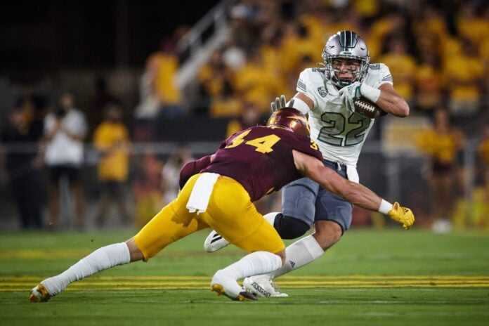 Eastern Michigan Eagles running back Samson Evans (22) attempts to block a tackle by Arizona State Sun Devils linebacker Kyle Soelle.