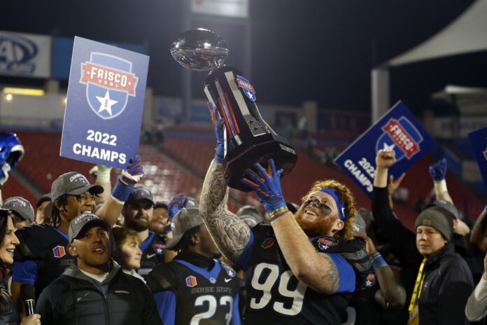 Scott Matlock (99) holds up the trophy after beating the North Texas Mean Green.