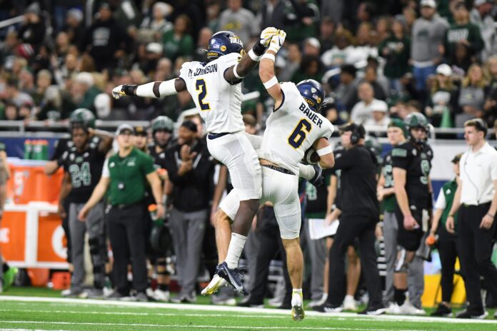 Toledo safety Nate Bauer (6) celebrates with linebacker Dyontae Johnson (2) after intercepting a pass against Ohio University in the second quarter at Ford Field.
