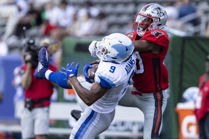 Jonathan Adams catches the ball with Tampa Bay Bandits defensive back Quenton Meeks on tight defense.