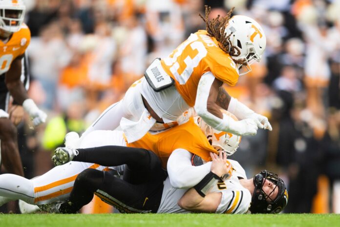 Jeremy Banks and teammate tackled Missouri quarterback Brady Cook during a game between Tennessee and Missouri.