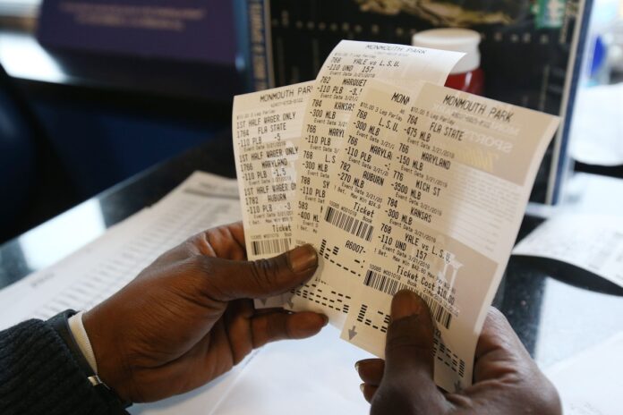 Charlie Rogers of Aberbeen, a former NFL player, displays his betting slips during March Madness.