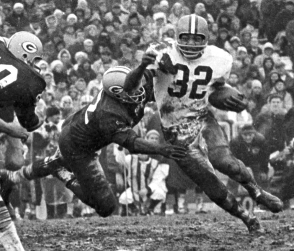Jim Brown (32) turns the corner as Green Bay Packers chase after him.