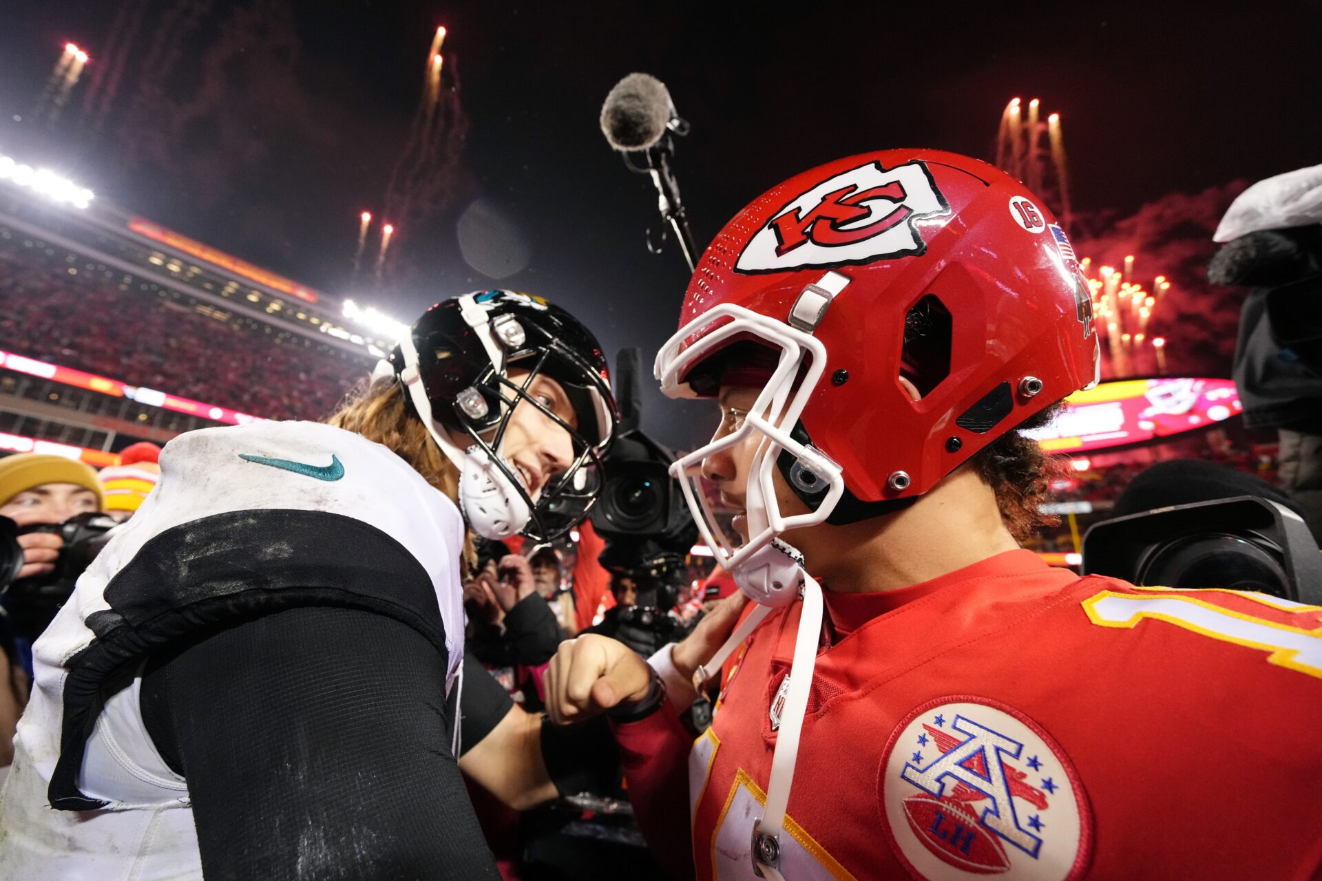 Patrick Mahomes (15) meets with Jacksonville Jaguars quarterback Trevor Lawrence (16) following the AFC divisional round game at GEHA Field at Arrowhead Stadium.