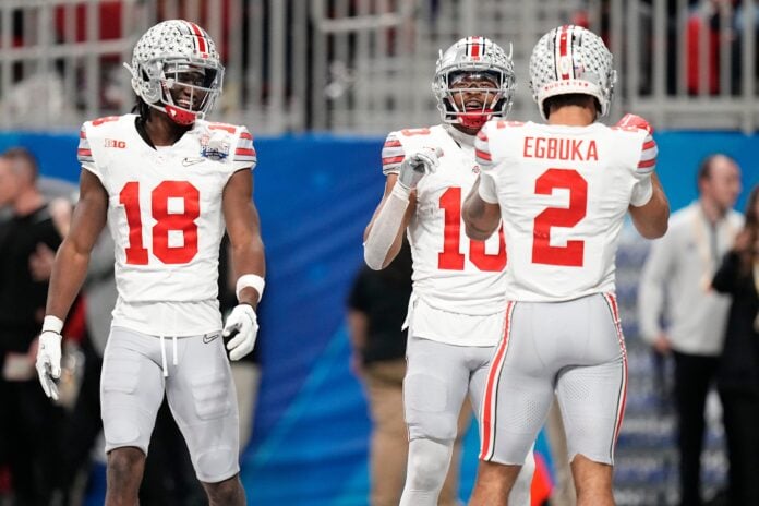 Ohio State wide receivers Marvin Harrison Jr. (18) and Emeka Egbuka (2) celebrate a touchdown with their fellow wideout.