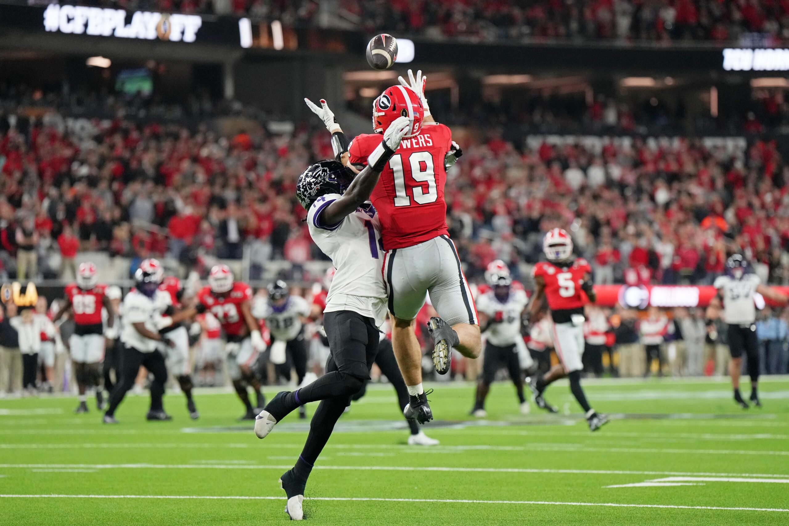 Georgia Bulldogs tight end Brock Bowers (19) makes a catch for a touchdown against TCU Horned Frogs safety Abraham Camara (14) during the third quarter of the CFP national championship game at SoFi Stadium. 