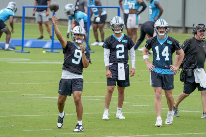 Bryce Young (9) throws with quarterback Matt Corral (2) and quarterback Andy Dalton (14) watching during the Carolina Panthers minicamp.