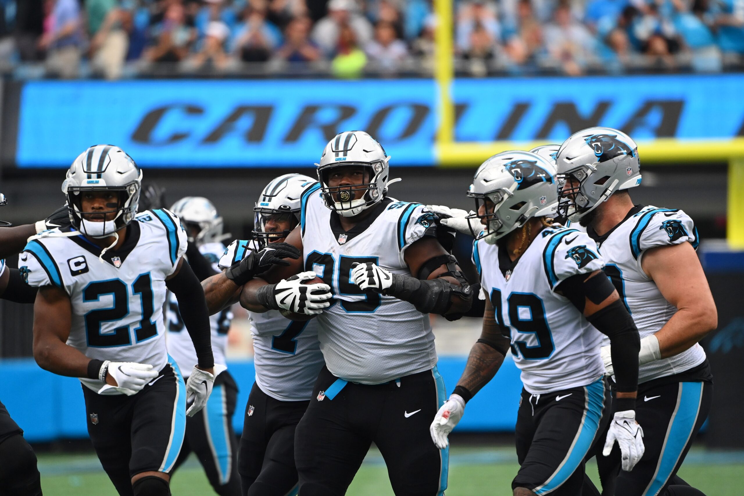 Derrick Brown (95) celebrates with safety Jeremy Chinn (21) and linebacker Shaq Thompson (7) and linebacker Frankie Luvu (49) and defensive tackle Matt Ioannidis (99) after intercepting a pass in the fourth quarter at Bank of America Stadium.
