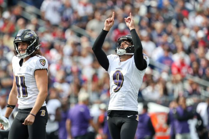 Justin Tucker (9) reacts after an extra point during the first half against the New England Patriots at Gillette Stadium.