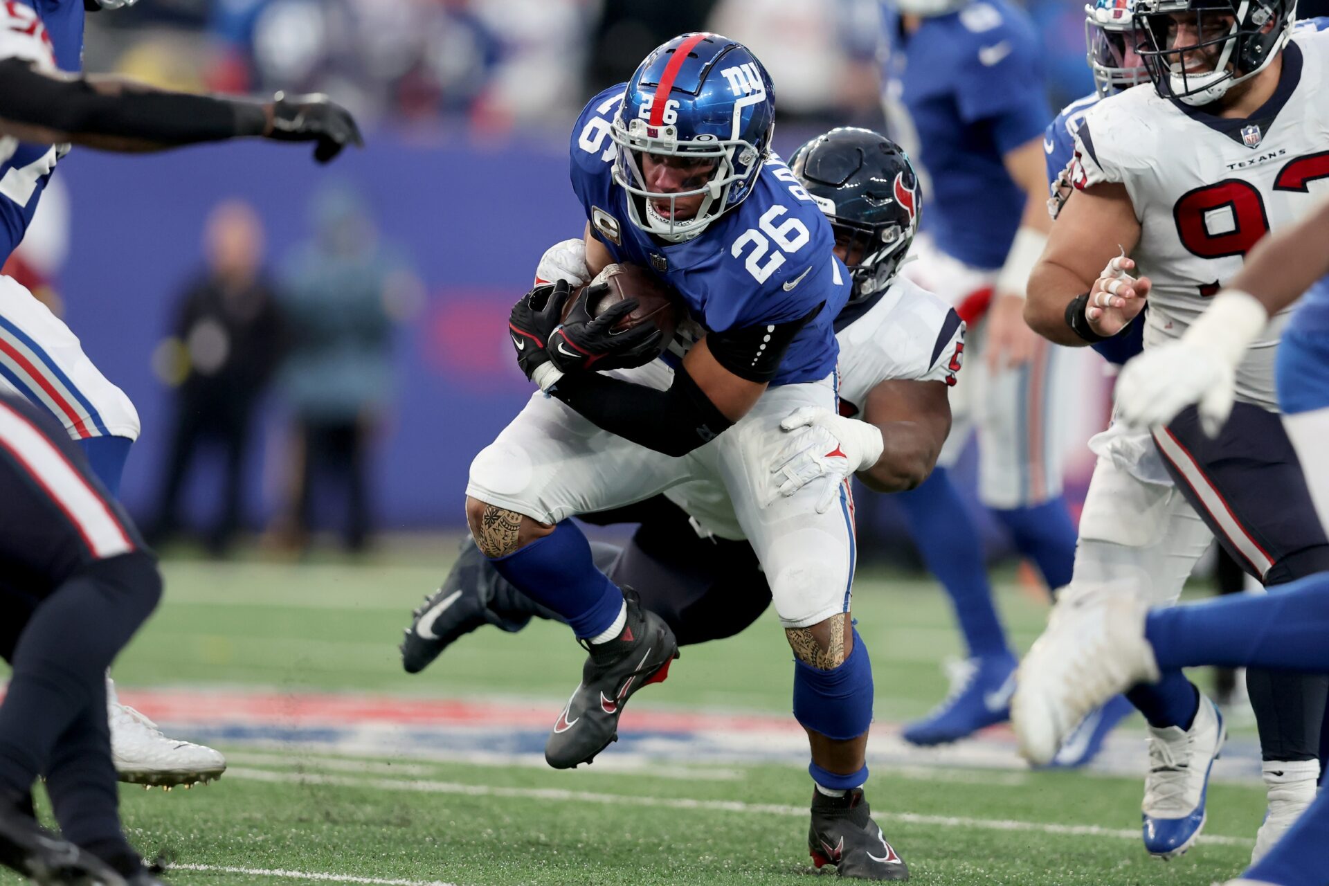 New York Giants RB Saquon Barkley (26) tries to avoid tackles from the Houston Texans' defense.