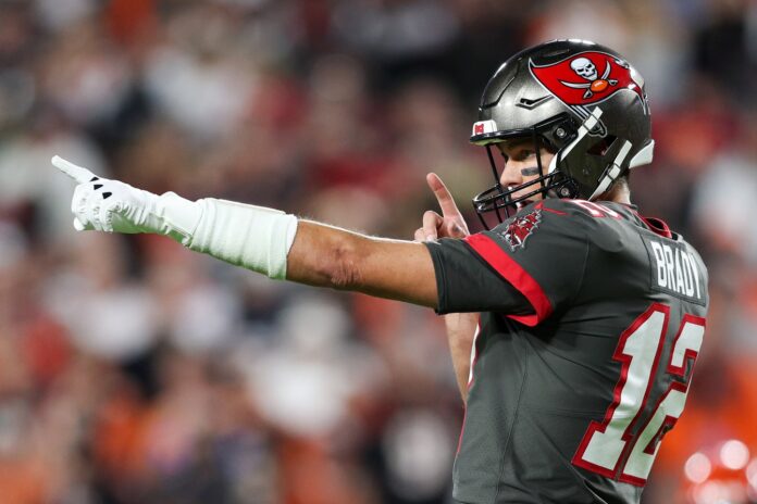 Tampa Bay Buccaneers QB Tom Brady (12) points in celebration after a play.