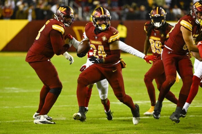 Washington Commanders running back Antonio Gibson (24) runs with