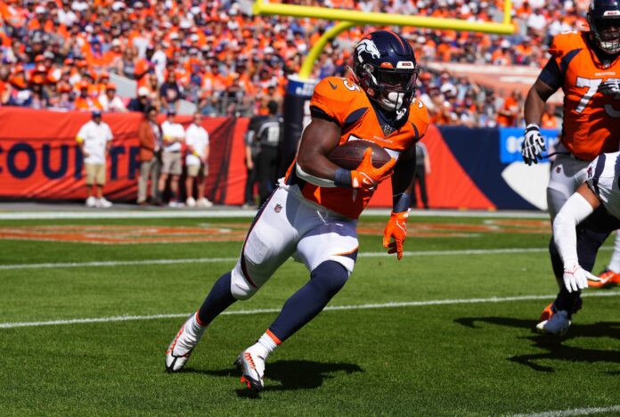 Denver Broncos running back Javonte Williams (33) is tackled by