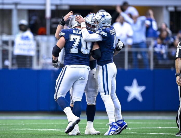 Dak Prescott (4) and guard Zack Martin (70) celebrates a touchdown scored by running back Tony Pollard (not pictured) during the second half against the Chicago Bears at AT&T Stadium.