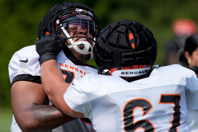 Cincinnati Bengals offensive tackle Orlando Brown Jr. (75) and guard Cordell Volson (67) run a drill during a training camp practice at the Paycor Stadium practice facility.