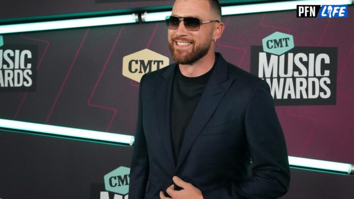 Travis Kelce poses for cameras at Country Music Awards.