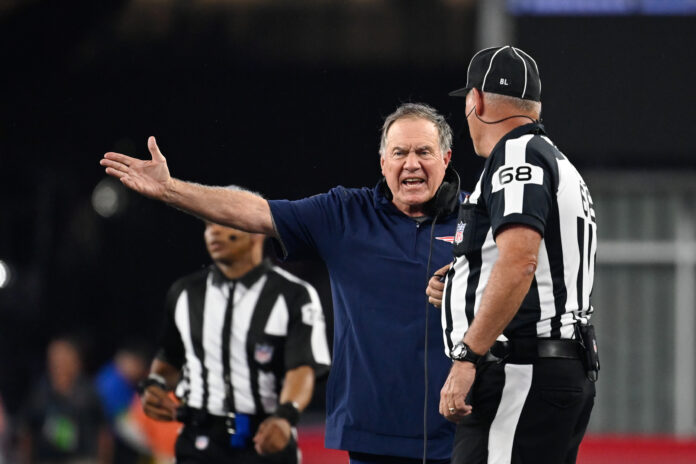 New England Patriots head coach Bill Belichick looks up to the