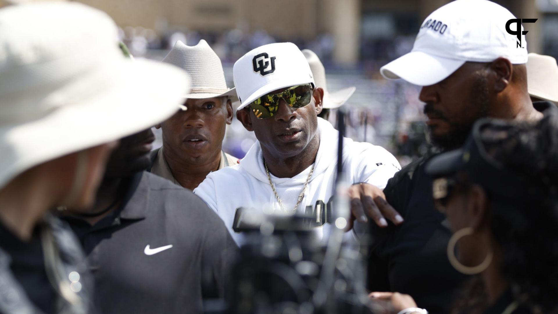 Baltimore Ravens' Deion Sanders, right, hops over Buffalo Bills