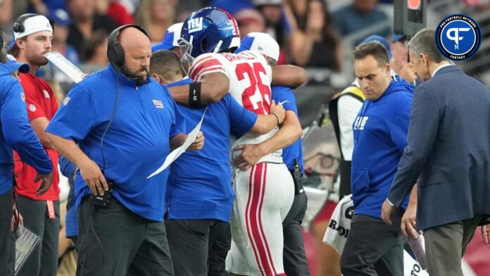 New York Giants head coach Brian Daboll looks on as New York Giants running back Saquon Barkley (26) is helped off the field during the second half of the game against the Arizona Cardinals at State Farm Stadium.