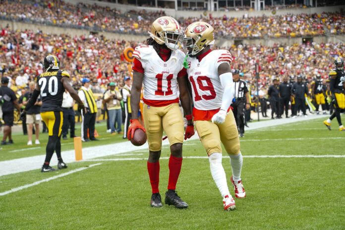 Deebo Samuel (19) congratulates San Francisco 49ers wide receiver Brandon Aiyuk (11) for catching a touchdown pass against the Pittsburgh Steelers during the first half at Acrisure Stadium.
