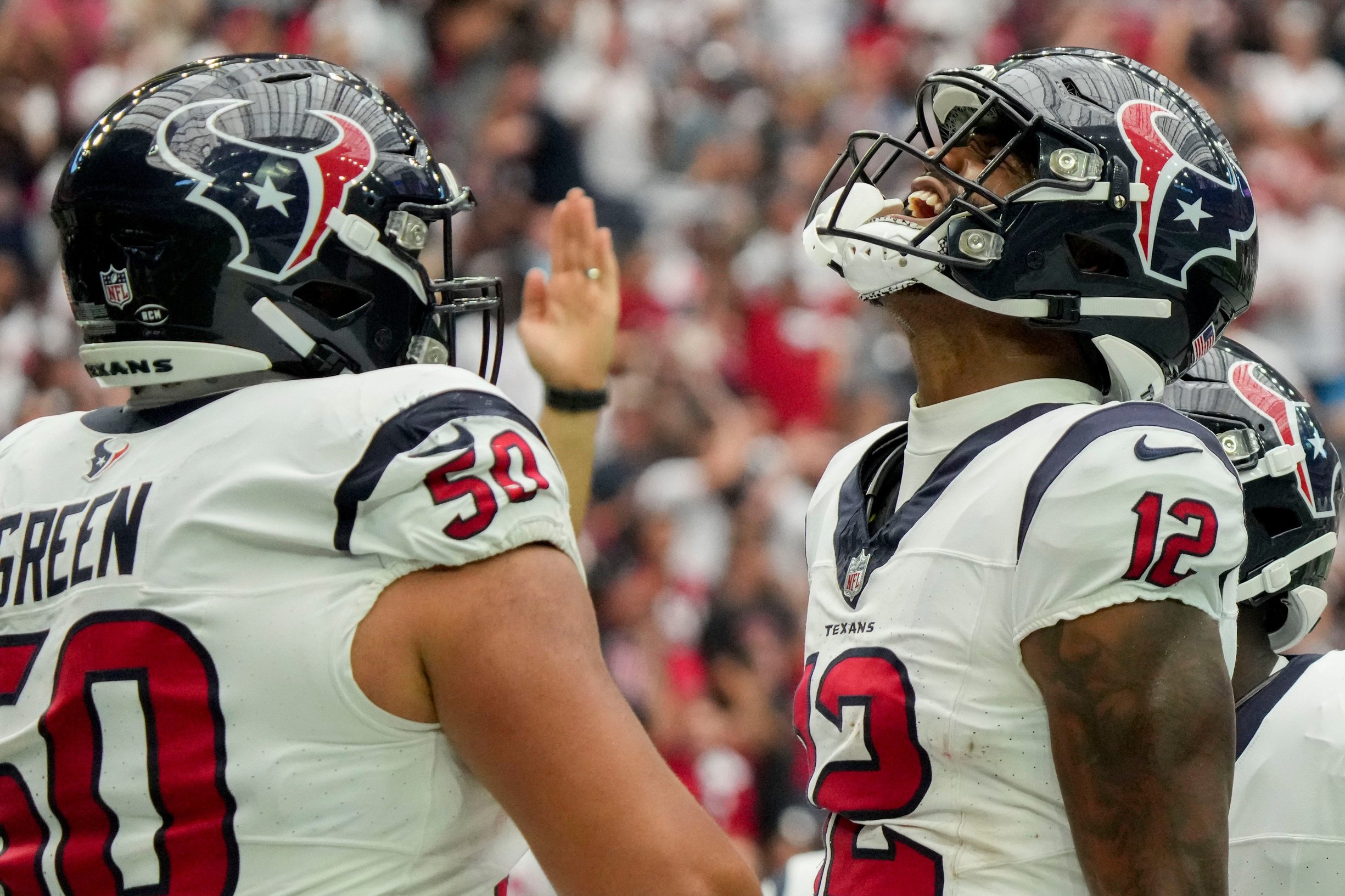 Kendrick Green (50) celebrates with Houston Texans wide receiver Nico Collins (12) after making a touchdown catch.