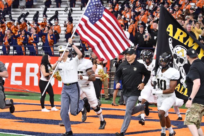 Army Black Knights head coach Jeff Monken and defensive back Cameron Jones (10) lead the team onto the field before a game against the Syracuse Orange at the JMA Wireless Dome.