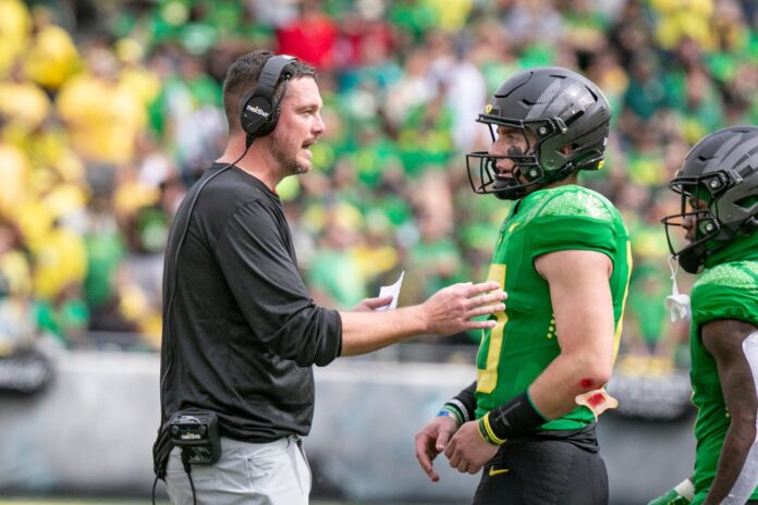 Oregon head coach Dan Lanning talks to quarterback Bo Nix during a timeout in the first half as the Oregon Ducks host Colorado in the Pac-12 opener.