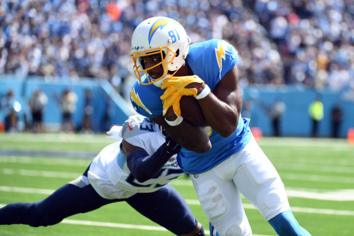 Sep 17, 2023; Nashville, Tennessee, USA; Los Angeles Chargers wide receiver Mike Williams (81) runs after a reception against Tennessee Titans cornerback Tre Avery (23) during the first half at Nissan Stadium. Mandatory Credit: Christopher Hanewinckel-USA TODAY Sports