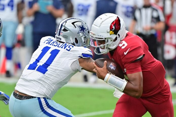 Arizona Cardinals quarterback Joshua Dobbs (9) escapes a tackle from Dallas Cowboys linebacker Micah Parsons (11) in the first half at State Farm Stadium.