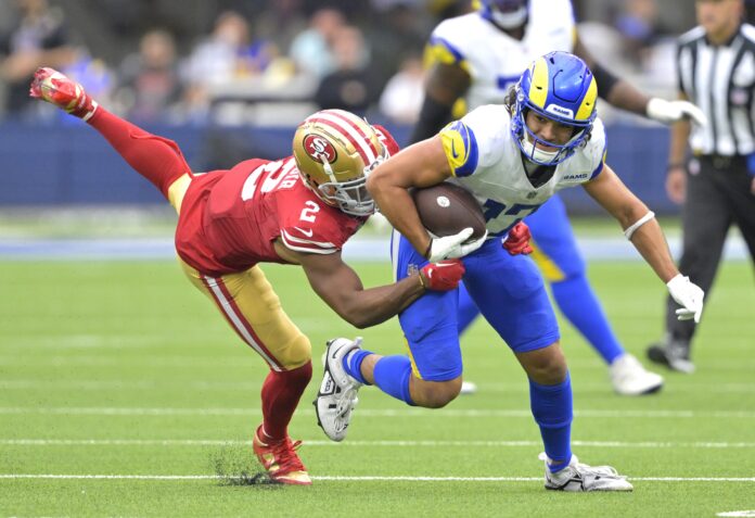 Los Angeles Rams WR Puka Nacua runs through the tackle of San Francisco 49er defender.