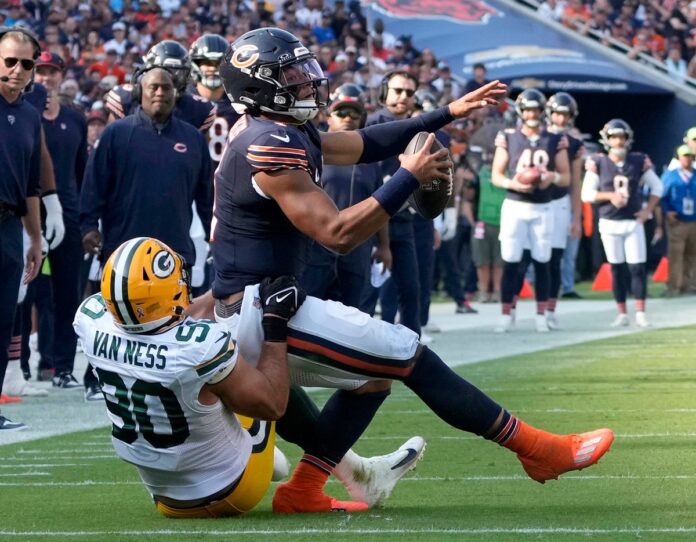 Green Bay Packers linebacker Lukas Van Ness (90) makes an open field tackle on Chicago Bears quarterback Justin Fields (1) near the end zone during the second quarter of their game on Sunday, Sept. 10, 2023, at Soldier Field in Chicago.