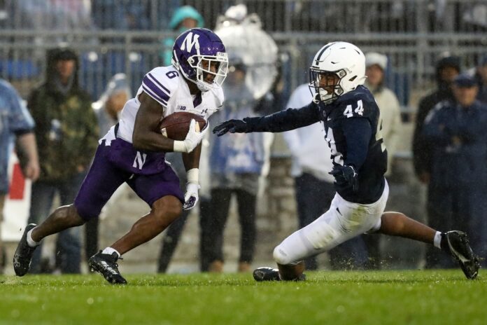 Northwestern Wildcats wide receiver Malik Washington (6) runs the ball against Penn State Nittany Lions defensive end Chop Robinson (44).