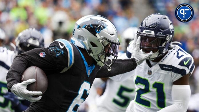 Miles Sanders (6) stiff-arms away from a tackle attempt by Seattle Seahawks cornerback Devon Witherspoon (21) during the second quarter at Lumen Field.