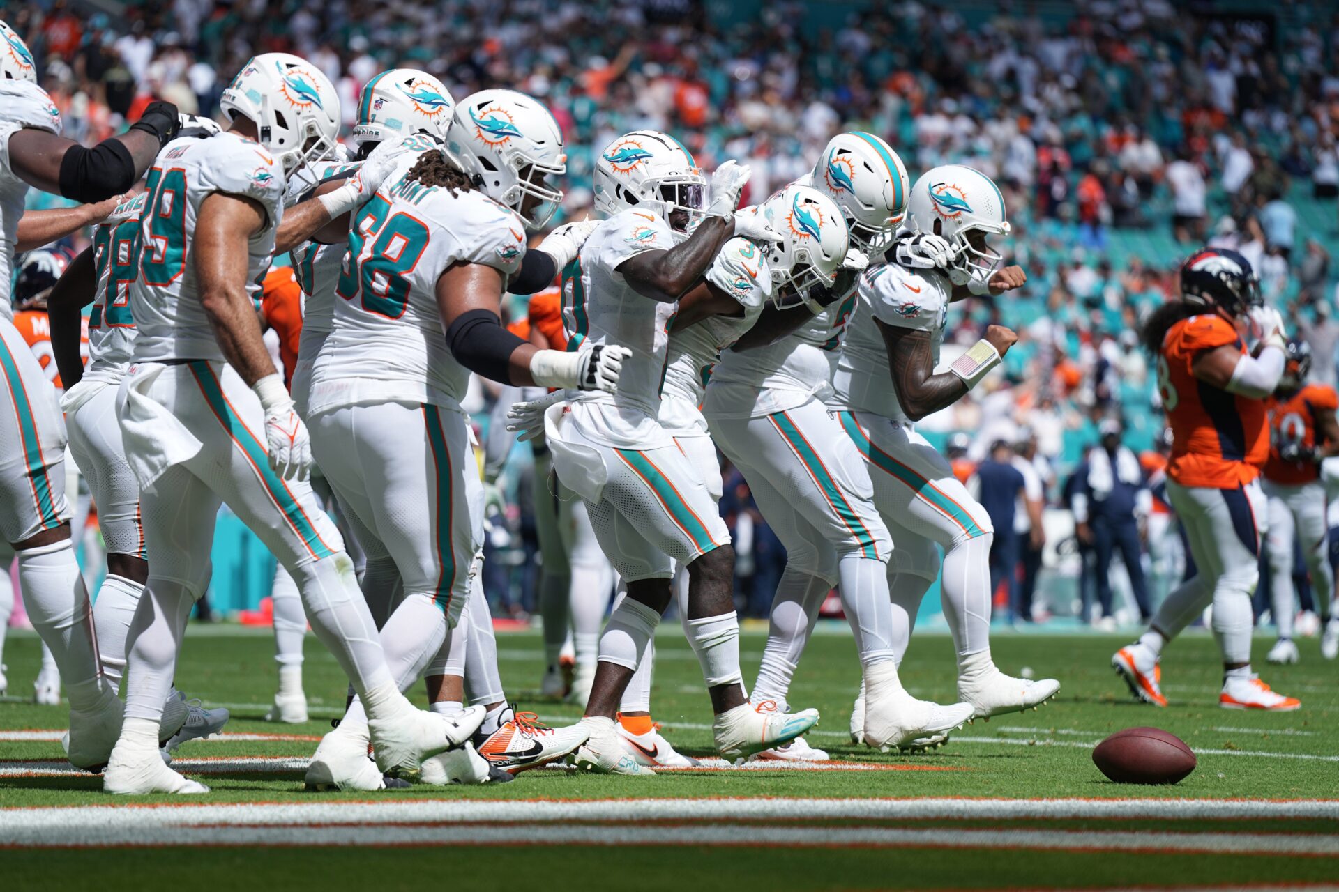 The Miami Dolphins offense does a dance routine after scoring against the Denver Broncos in the second quarter of an NFL game at Hard Rock Stadium.