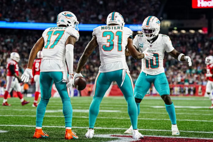 Miami Dolphins Tyreek Hill, Raheem Mosert, and Jaylen Waddle celebrate after TD vs. the New England Patriots.