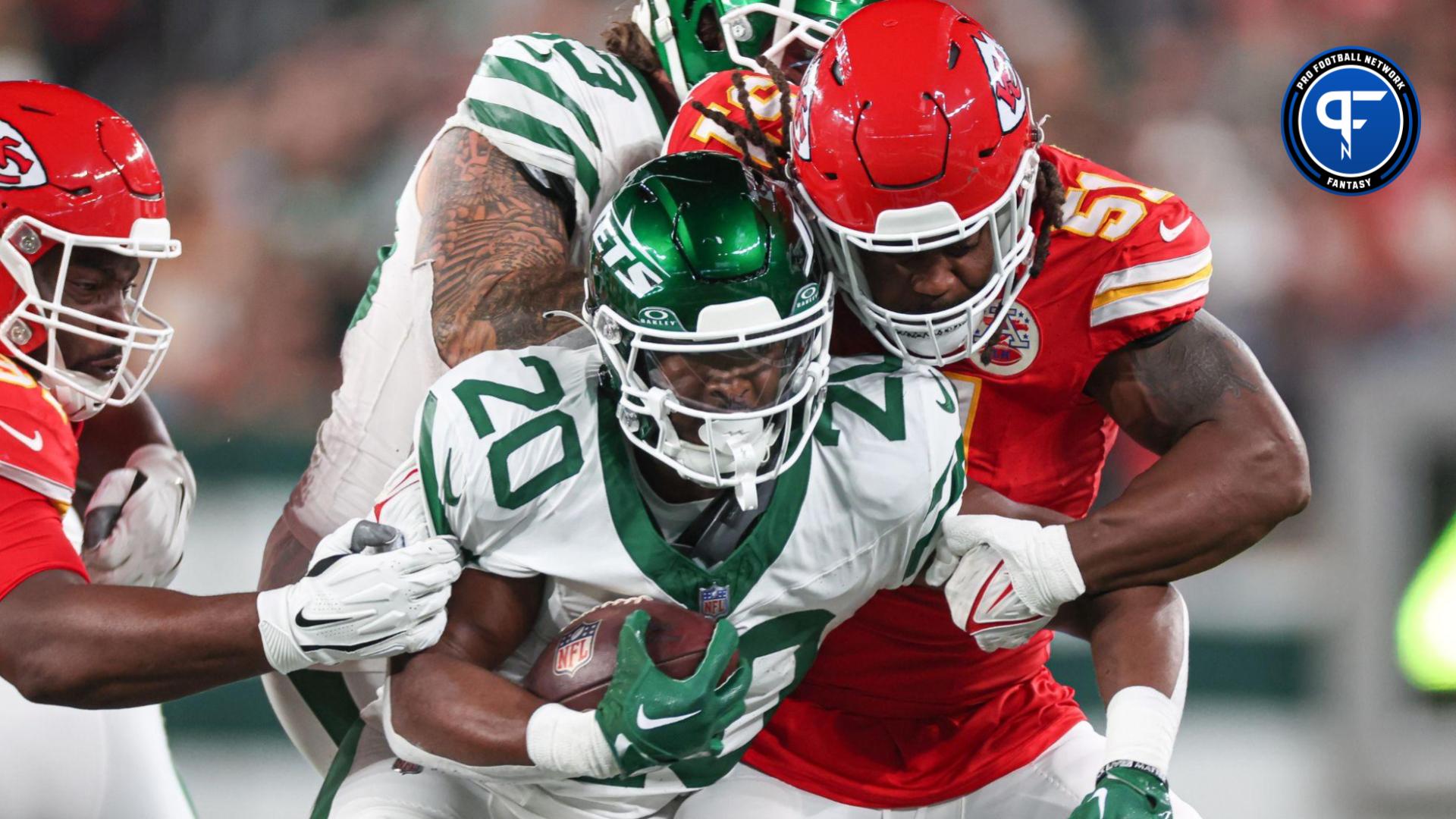 New York Jets RB Breece Hall (20) gets tackled by Kansas City Chiefs defenders.