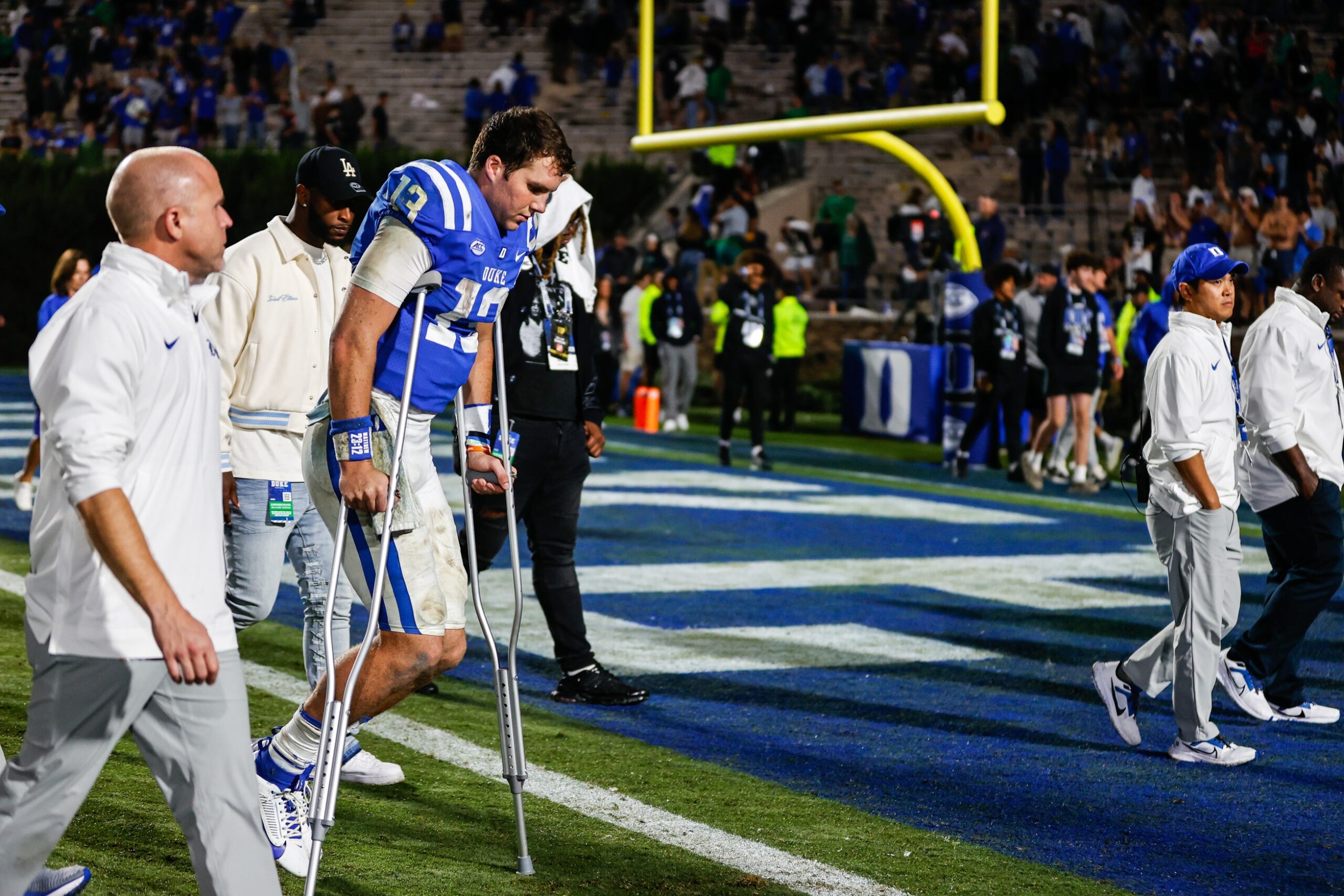 Duke Blue Devils quarterback Riley Leonard (13) leaves the field on crutches as fans cheer for him at the end of the game against Notre Dame Fighting Irish.