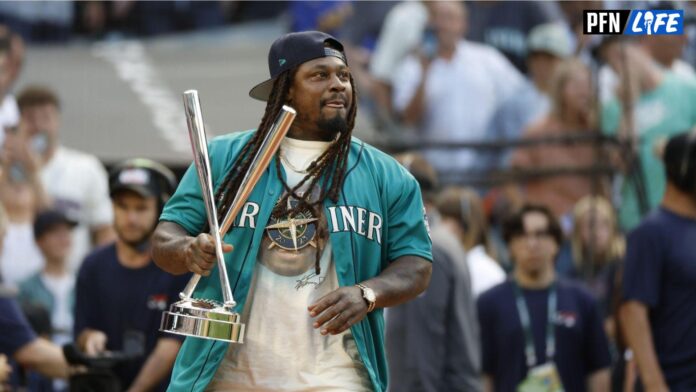 Former Seattle Seahawks running back Marshawn Lynch brings the championship trophy to the field.
