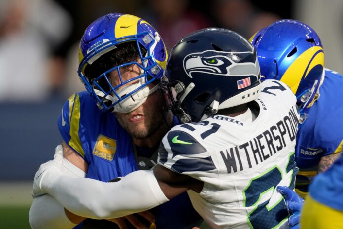 Seattle Seahawks cornerback Devon Witherspoon (21) sacks Los Angeles Rams quarterback Matthew Stafford (9) in the first quarter at SoFi Stadium.
